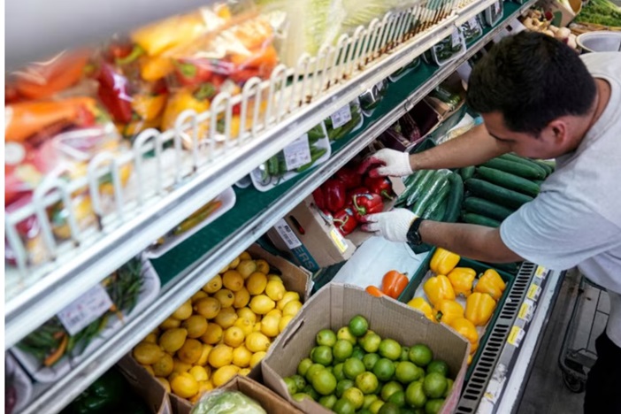 一名男子在美国华盛顿特区芒特普莱森特附近的 Best World 超市安排农产品