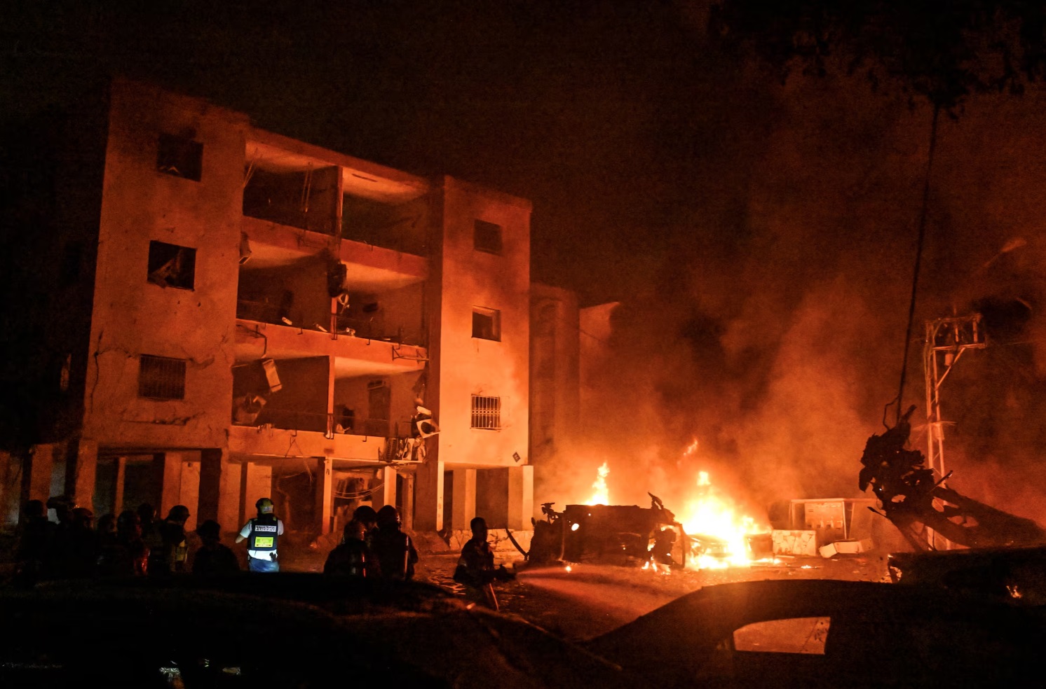 以色列海法，消防员和救援人员在伊朗导弹袭击后的撞击现场工作